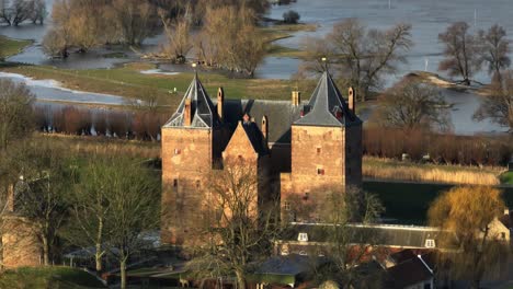 Drone-footage-of-Slot-Loevestein-flooded-in-rain-waters-along-the-Waal-River-in-Varik,-Gelderland,-Netherlands