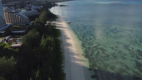 Tilt-up-drone-shot-of-white-sand-coastline-of-Saipan,-Northern-Mariana-Islands