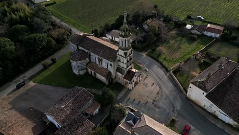 Aerial-of-Notre-Dame-Church-amid-vineyards,-France