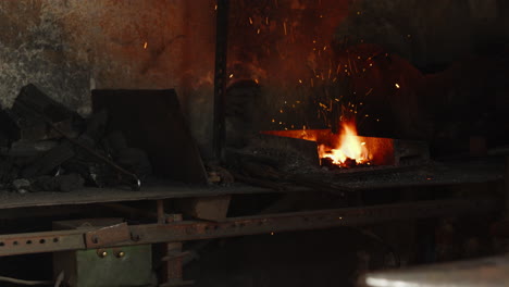 A-blacksmith's-workshop,-with-the-coal-forge-running,-incandescent-particles-flying-through-the-air