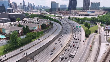 Epic-aerial-view-of-Atlanta-expressway-traffic-with-modern-skyline-buildings-in-view,-Georgia,-USA