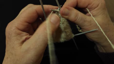 Grandmother-Expertly-Knitting-with-Traditional-Spears,-Handicraft-with-Natural-Sheep-Wool,-Timeless-Craft-Closeup
