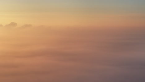 Sunrise-drone-view-panning-right-to-left-above-golden-winter-fog