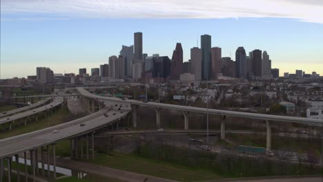 Descending-drone-shot-of-downtown-Houston,-Texas-and-surrounding-landscape