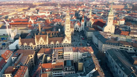 Aerial-approaching-shot-of-Marienplatz-Mary's-Square-with-townhall-in-Munich-during-golden-sunset,-Germany