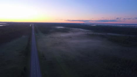 Foggy-morning-drone-shot-on-the-east-coast-over-the-Trans-Canada-Highway-with-lots-of-trees-and-landscape