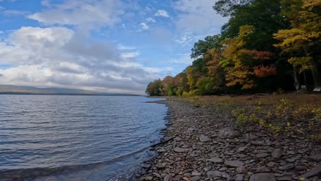 -A-beautiful-day-on-a-stunning,-rocky-fall-lake-shore-with-beautiful-clouds-60fps