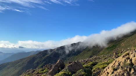 Cool-rolling-clouds-on-top-of-Sierra-Bermeja-mountain-in-Estepona-Malaga-Spain,-green-nature-park,-sunny-day-and-blue-sky,-4K-shot