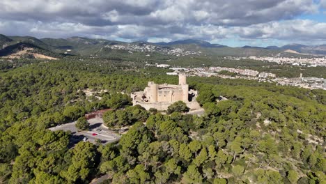 Aerial-view-of-Castell-de-Bellver-in-Palma-City-surrounded-by-green-mountain-landscape-on-Mallorca-Island