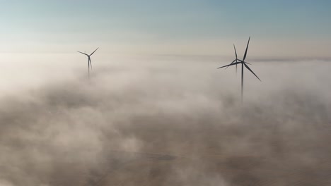 Luftaufnahme-Eines-Windparks,-Umgeben-Von-Nebel-Im-Ersten-Licht