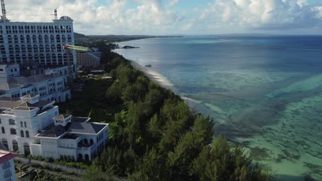 Drone-shot-of-buildings-and-trees-along-coastline-of-Saipan-island