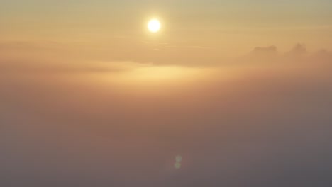 Drohnenansicht-Des-Sonnenaufgangs,-Während-Er-Aus-Dem-Morgennebel-Aufsteigt