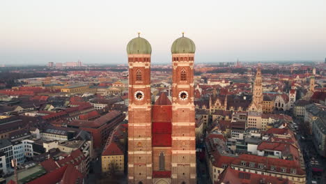 Aerial-closing-to-the-Munich-Frauenkirche,-Rathaus,-Alter-Peter-and-Innenstadt,-showcasing-its-two-towering-spires-with-awe-inspiring-grandeur