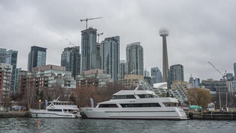 Winter-Clouds-Hiding-CN-Tower-And-Toronto-Skyline,-Luxury-Yachts-In-Harbour