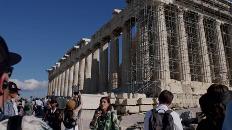 Tourists-visiting-the-historical-Parthenon-temple,-woman-introducing-the-temple-with-a-video