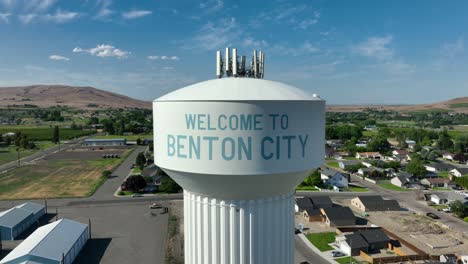 Lowering-drone-shot-of-Benton-City's-welcome-message-on-their-water-tower