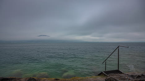 Overcast-day-by-the-lake-with-a-metal-staircase-leading-into-the-water-time-lapse