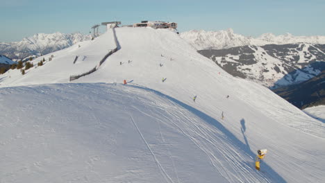 Menschen-Skifahren-In-Einem-Verschneiten-Bergskigebiet-In-Saalbach-Hinterglemm,-Österreich---Drohnenaufnahme