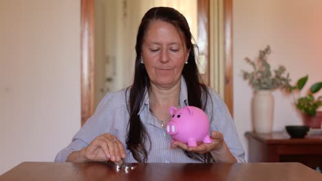 A-Joyous-Woman-Depositing-Money-into-a-Piggy-Bank---Static-Shot