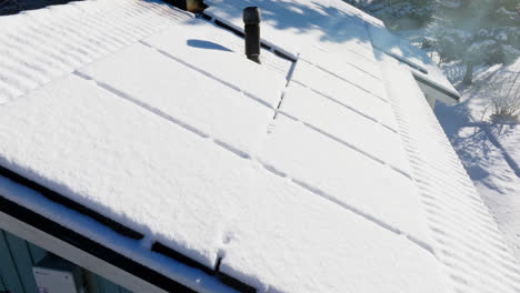 Luftaufnahme-Rund-Um-Sonnenbeschienene,-Schneebedeckte-Solarzellen-Auf-Einem-Einfamilienhaus-In-Finnland