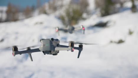 DJI-Air-3-Hovering-In-Front-Of-Air-2S-With-Bokeh-Snow-White-Background