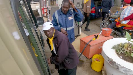 Conductor-Keniano-Abriendo-La-Tapa-De-Gasolina-Del-Vehículo-En-Una-Gasolinera-En-Narok,-Kenia