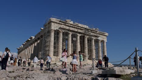 A-part-of-the-famous-Parthenon-temple-is-under-restoration,-tourists-visiting-the-temple