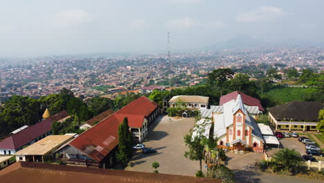 Aerial-view-backwards-over-the-Basilique-Marie-Reine-des-Apôtres,-in-sunny-Yaounde,-Cameroon