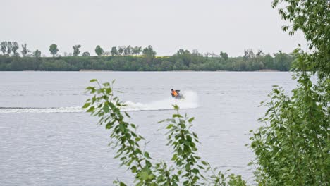 A-water-scooter-sailing-Through-the-Lake,-Creating-a-Splash-of-White-Water-in-its-Wake---Wide-slow-motion-Shot