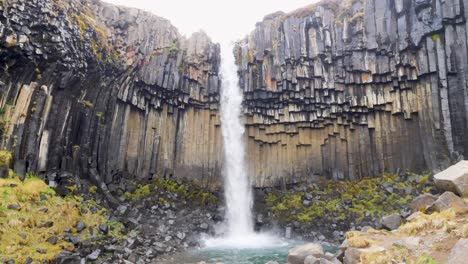 Svartifoss-Wasserfall-In-Island,-Der-Schwarze-Basaltsäulen-Hinabstürzt,-Umgeben-Von-Schroffen-Klippen