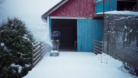 A-Man-is-Employing-a-Snow-Blower-to-Remove-the-Accumulated-Snow-in-Indre-Fosen,-Trondelag-County,-Norway---Static-Shot