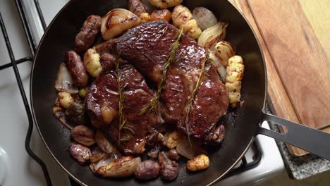 Delectable-Roasted-Beef-in-a-Skillet-with-Potatoes,-Onions,-and-Rosemary-Leaves---Close-Up