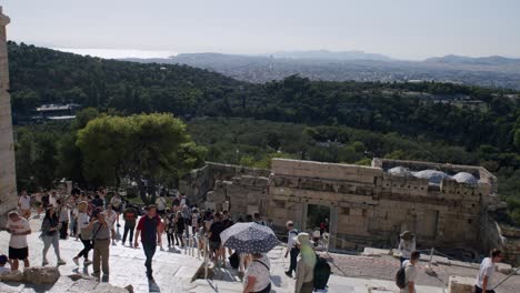 Tourists-visiting-the-Parthenon-temple-on-a-sunny-summer-day,-people-climbing-the-old-staircase