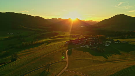 Sonnenuntergang-über-Einem-Ländlichen-Dorf-In-Der-Nähe-Des-Attersees-Mit-Sonne,-Die-über-Die-Berge-Blickt,-Luftaufnahme