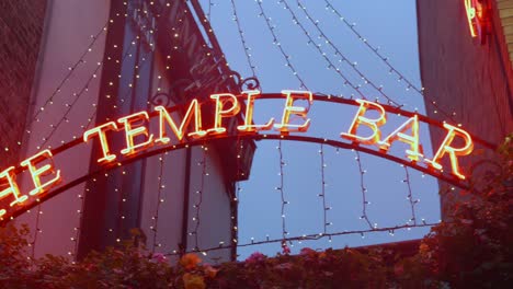 Close-up-pan-right-entrance-sign-of-famous-The-Temple-Bar-with-christmas-lights