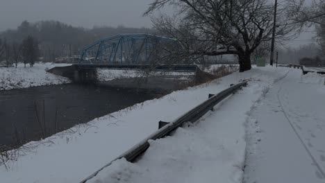 Blue-arched-steel-bridge-crossing-the-Roundout-creek-on-a-snowy-day-in-Rosendale,-New-York