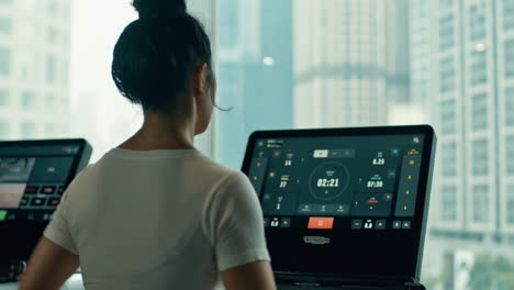 Young-asian-woman-doing-cardio-exercises-on-Technogym-treadmill