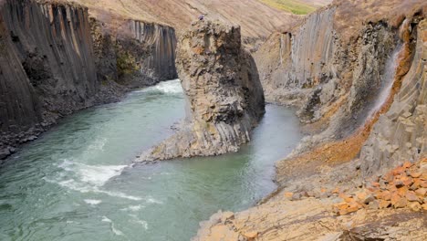 Static-shot-of-person-on-a-Basalt-stack-in-Studlagil-Canyon-in-East-Iceland