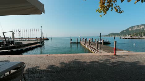 POV-Hyperlapse-Walking-Along-Lake-Garda-Promenade-Towards-Pier-On-Sunny-Day