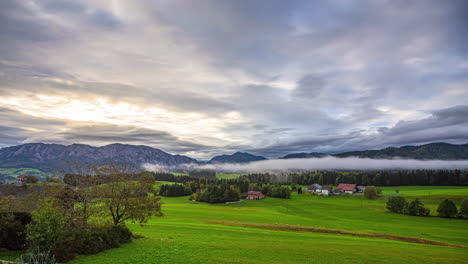 Misty-morning-over-a-valley-with-rolling-hills-and-a-serene-sky-at-dawn-time-lapse