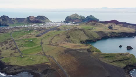Luftaufnahme-Eines-Ruhigen-Isländischen-Dorfes,-Umgeben-Von-Dramatischen-Landschaften-Und-Küstenmerkmalen-Bei-Tag