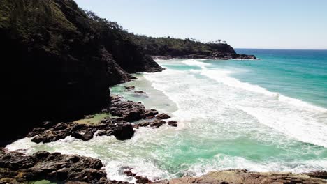 Idyllischer-Strand-Mit-Schäumenden-Meereswellen-Und-Tropischer-Vegetation-In-Noosa,-Queensland,-Australien-–-Drohnenrückzug
