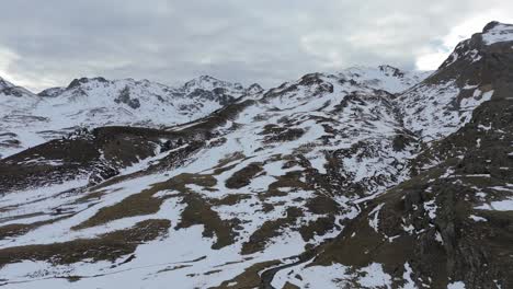 Drone-advancing-towards-a-snowy-mountain-located-in-Portalet-sky-station,-Spain