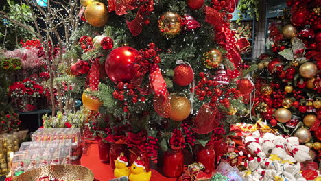 Christmas-tree-decorated-with-golden-and-red-balls-spins-on-a-turntable-at-shopping-mall,-christmas-spirits-and-mood