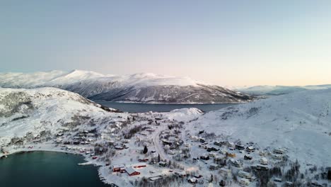 Aerial-establishing-shot-of-ersfjordvegen-surrounded-by-snowy-mountains