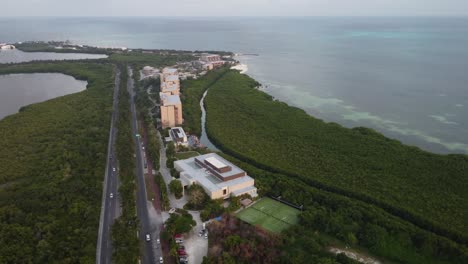 Aerial-establishing-shot-of-rows-of-resorts-along-Punta-Nizuc-Bridge,-Cancun