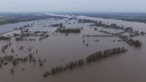 Aerial-wide-view-of-flooded-farm-fields-along-the-Waal-River-near-Gorinchem-Netherlands,-after-heavy-rains-drench-most-of-Northern-Europe