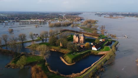 Low-aerial-orbiting-view-of-the-historic-Slot-Loevestein-castle-surrounded-by-flood-waters-as-the-Waal-River-overflows-its-banks-after-heavy-rains-pummel-Northern-Europe