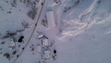 Toma-Aérea-De-Drones-Sobre-Una-Pequeña-Ciudad-Rural-Cubierta-Por-Una-Capa-De-Nieve-Durante-El-Invierno-En-Ersfjordvegen,-Noruega