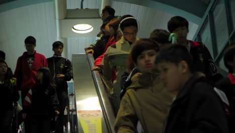 Flow-of-teenagers-and-students-descending-moving-staircase-in-public-transport-transit